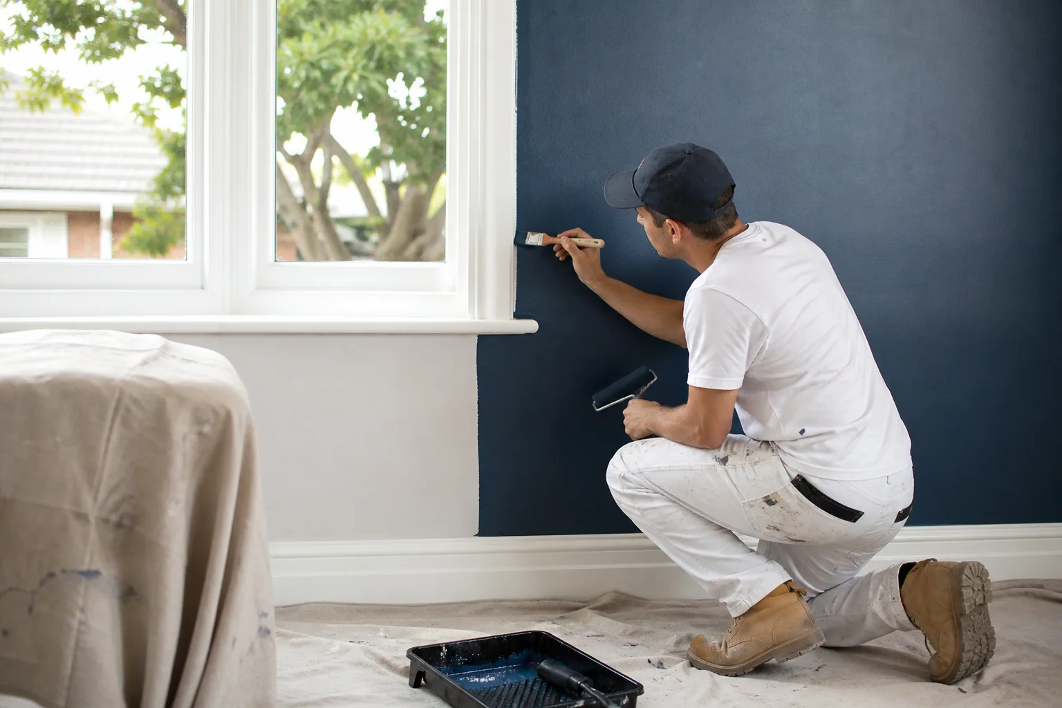 Painter cutting in a fresh coat around a door frame